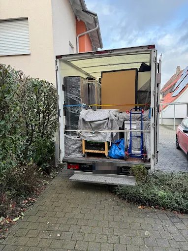 Blick von hinten in den beladenen Transporter mit Sackkarre und gesicherter Ladung.